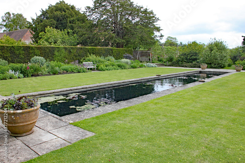 Fototapeta Naklejka Na Ścianę i Meble -  Rectangular ornamental pond in an English country garden