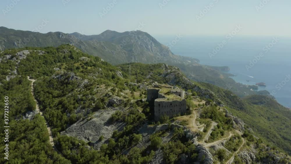Aerial view of medieval fortress Fort Kosmac in Montenegro. Drone shot ruin of an old stone fortress on the top of the hill.