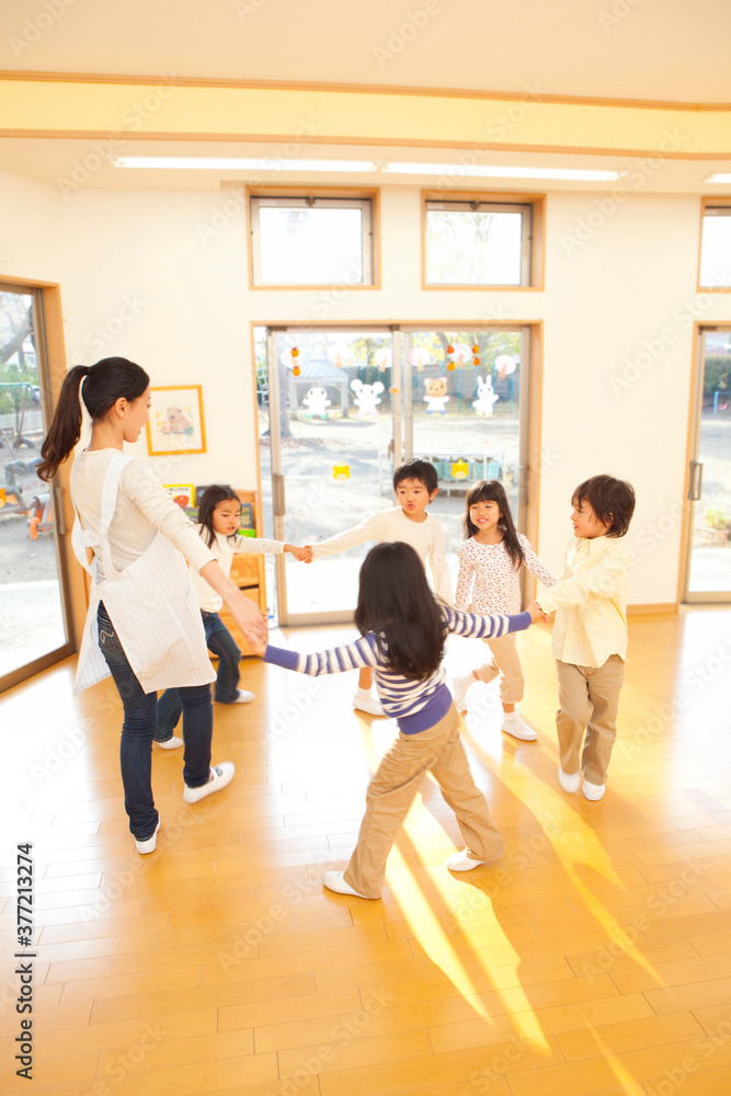 Fototapeta premium 輪になって踊る保育士と保育園児