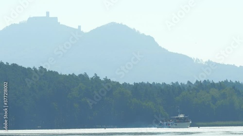 Steam ship named Maj with tourist on board on Machovo lake with Bezdez castle at background. Popular summer resort. photo