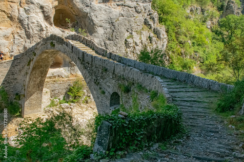 old stone Kokkoris bridge over river in the mountains of Zagori in summer, Greece