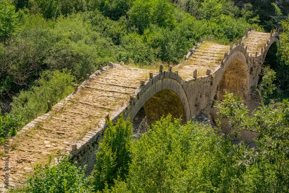 Three arches bridge of Kalogeriko over a little river in the north greek nature