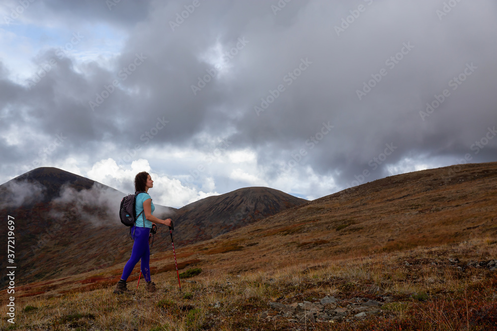 Adventurous Girl Hiking up the Nares Mountain during a cloudy and sunny evening. Taken at Carcross, near Whitehorse, Yukon, Canada. Adventurous Girl Hiking up the Nares Mountain during a cloudy and sunny evening. Taken at Carcross, near Whitehorse, Yukon, Canada.