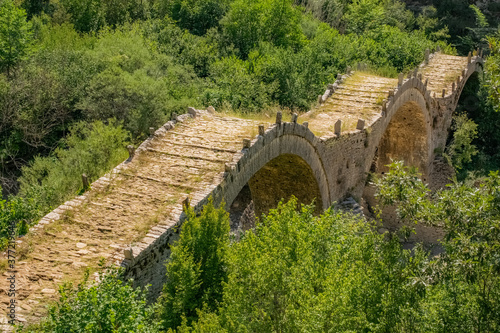 Three arches bridge of Kalogeriko over a little river in the north greek nature photo