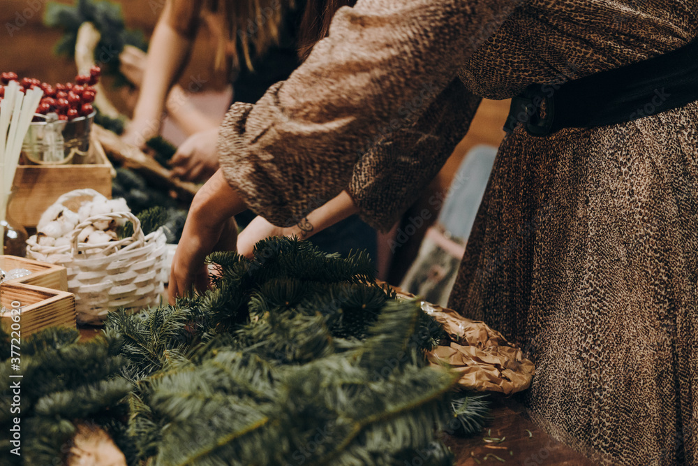 Woman making christmas wreath. Creating a Christmas wreath of spruce branches and a cardboard frame.