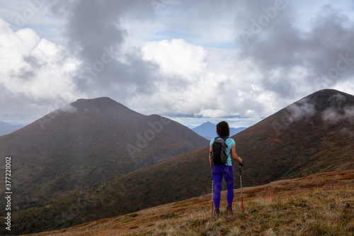 Adventurous Girl Hiking up the Nares Mountain during a cloudy and sunny evening. Taken at Carcross, near Whitehorse, Yukon, Canada. © edb3_16