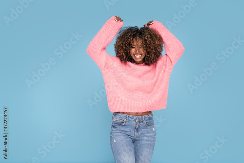 Happy smiling afro girl in pink sweater