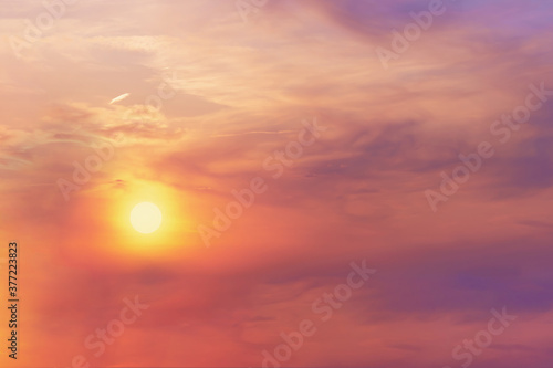 Fototapeta Naklejka Na Ścianę i Meble -  View of the bright orange halo of the sun in the evening sky at sunset. Landscape concept, background.