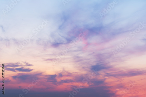 View of the sky in the evening at sunset with a dark cloud and a bright pink glow from the sun. Landscape concept, background.