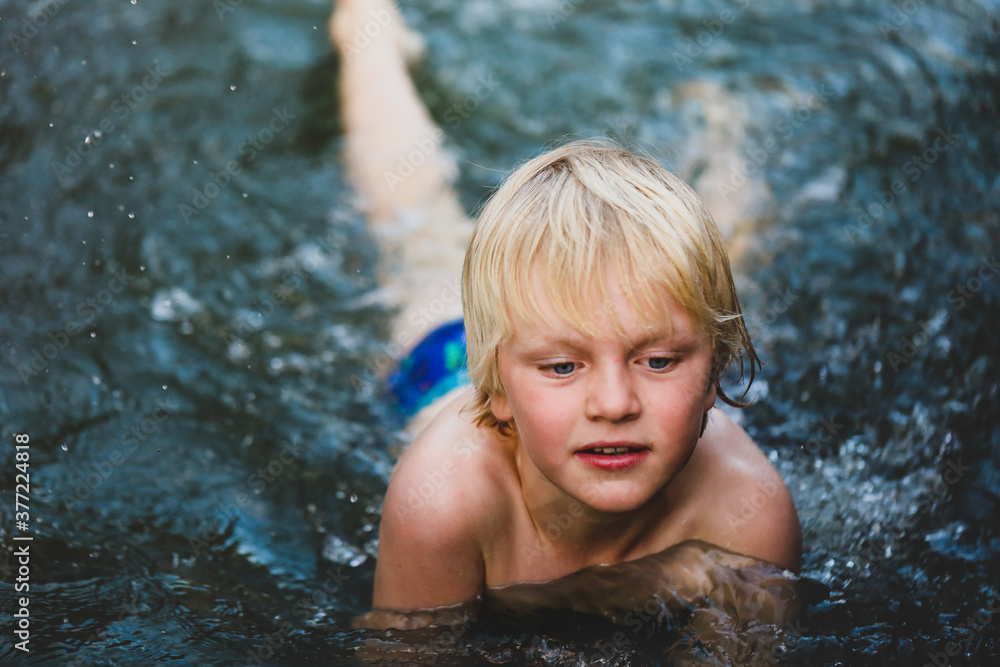 Obraz premium Boy swimming in natural swimming hole in central New South Wales, Australia