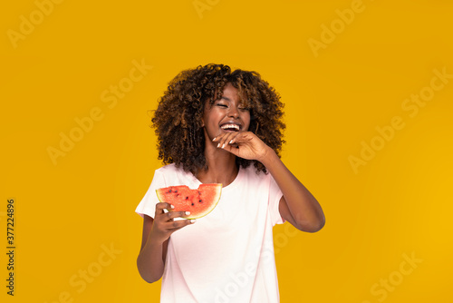 Afro girl eating watermelon .