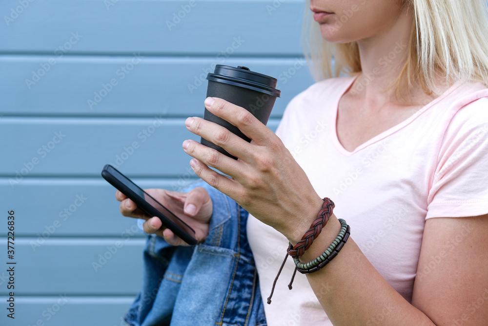Hippie wearing leather bracelets on a wrist holding a takeaway paper cup of coffee and smartphone, summer Stock Photo | Adobe Stock