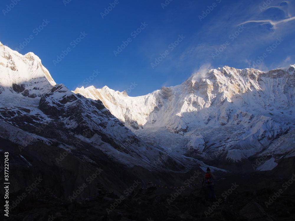 A mountain climber gaze at the snow-covered Himalayas, which rise majestically in the clear early morning air, ABC (Annapurna Base Camp) Trek, Annapurna, Nepal