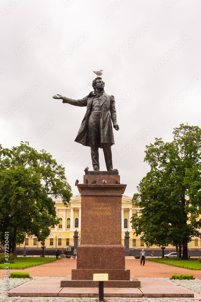 Seagull sits on the head of the monument to Alexander Pushkin on the square in front of the Russian Museum in St. Petersburg, Russia