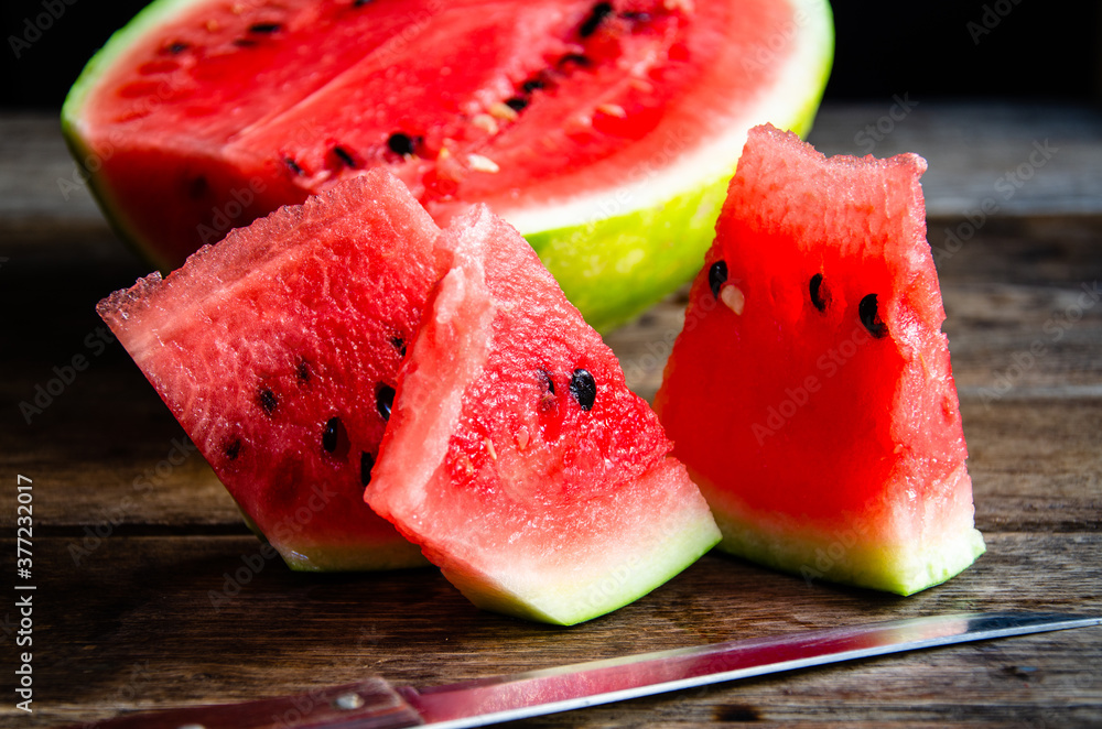 Ripe sliced watermelon on slices on a wooden table. Ripe sliced watermelon on slices on a wooden table.