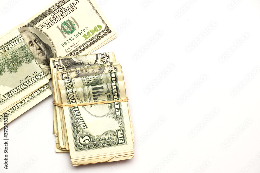 wad of dollars next to one hundred dollar bill. on white phone. economic concept. flat lay wad of dollars next to one hundred dollar bill. on white phone. economic concept. flat lay