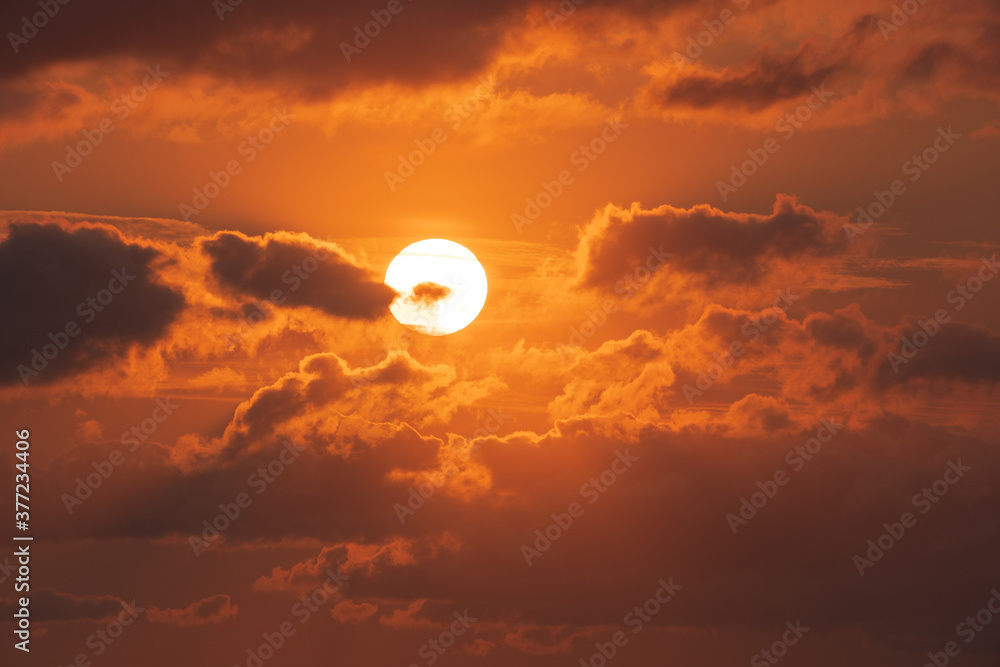 Deep orange colorful sun with clouds close to sunset. Nature background.