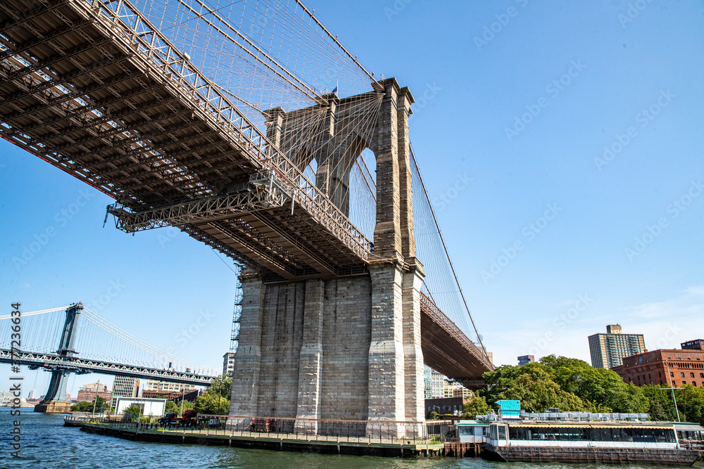 A view of the Brooklyn Bridge from the East River in New York City. A view of the Brooklyn Bridge from the East River in New York City.