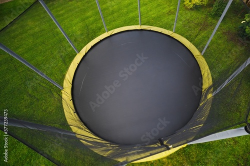 trampoline with big round mat on green lawn
