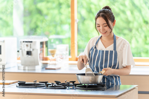 Cuadro en lienzo キッチンで料理をする女性