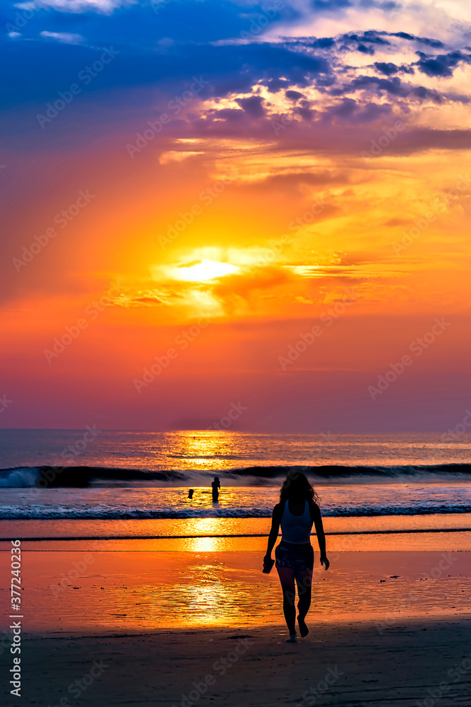 Silhouetted Woman on Beach at Sunset 