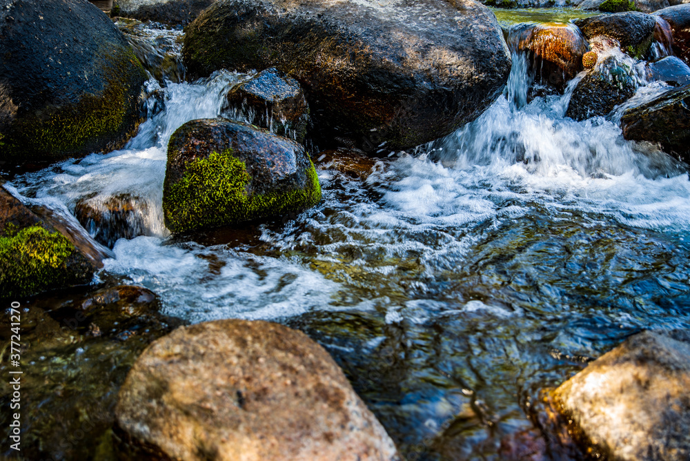water flowing over rocks in stream in the Eastern Sierra Nevada mountains of California water flowing over rocks in stream in the Eastern Sierra Nevada mountains of California
