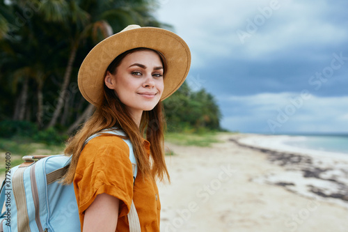  woman in hat smiles at the camera with a backpack on her back © SHOTPRIME STUDIO