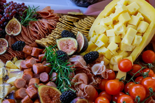 Charcuterie board with assortment of cheese, fruits and deli.