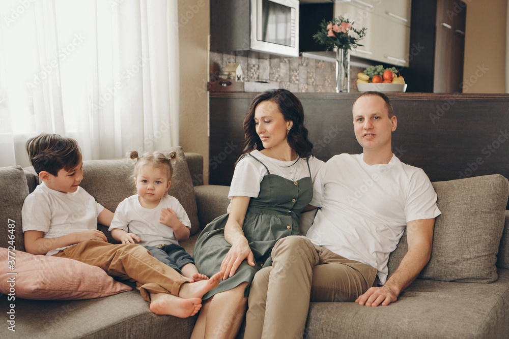 A family with two children is sitting on the sofa. Weekend at home. Spending time together A family with two children is sitting on the sofa. Weekend at home. Spending time together