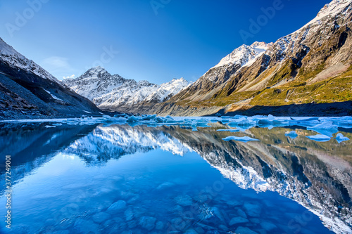Hooker lake with snow capped Mount Cook in the distance reflecting in the lake and a beautiful clear blue sky