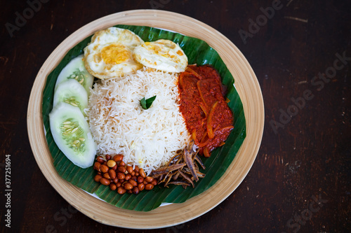 Photography Traditonal Malaysia Asian food Nasi Lemak on a banana leaf in a wooden bamboo plate