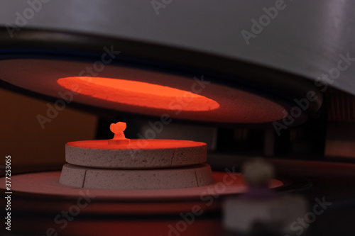 Man working in a prosthetic ceramic tooth cooking it.