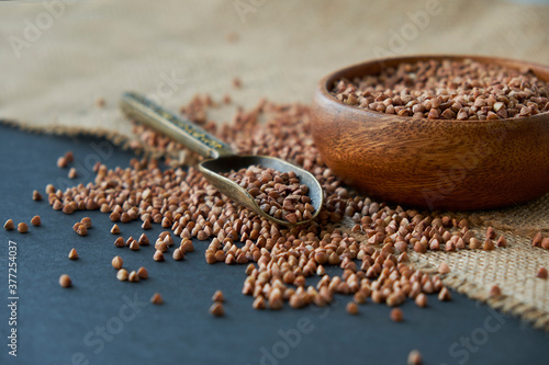 Canvas Print Buckwheat groats in a wooden bowl and vintage scoop