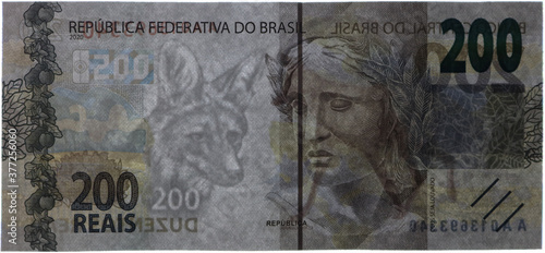 200 reais bill exposed over white light, revealing watermark and security thread. photo