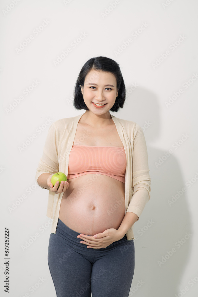 Pregnant mother eats apple happily and smiling. Pregnant mother eats apple happily and smiling.