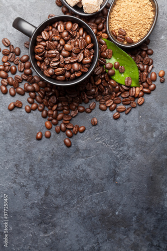 Coffee cup, sugar and roasted beans on dark stone table. Top view with copy space. Flat lay