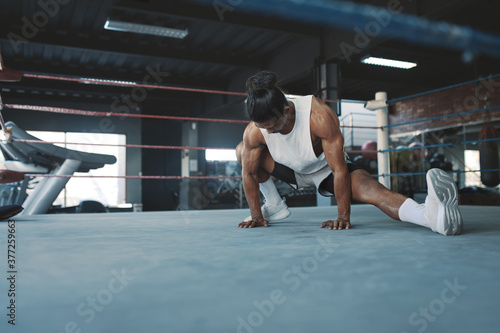 Workout. Man Stretching On Boxing Ring At Gym. Asian Sportsman Warming Up Before Intense Training. Bodybuilding For Strong  Healthy  Muscular Body. Sexy Guy Exercising At Fitness Center.