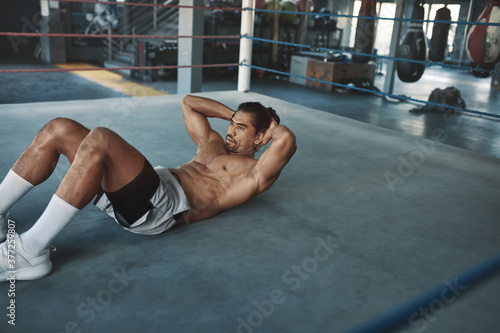 Abs Workout. Shirtless Man At Gym Doing Abdominal Exercise For Strong, Healthy, Muscular Body. Portrait Of Topless Sexy Asian Sportsman Training On Boxing Ring At Fitness Center.