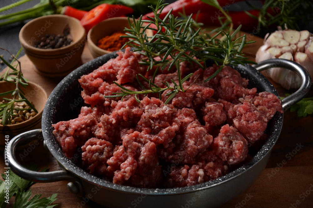 Minced beef. Ground meat with ingredients for cooking on black background Minced beef. Ground meat with ingredients for cooking on black background