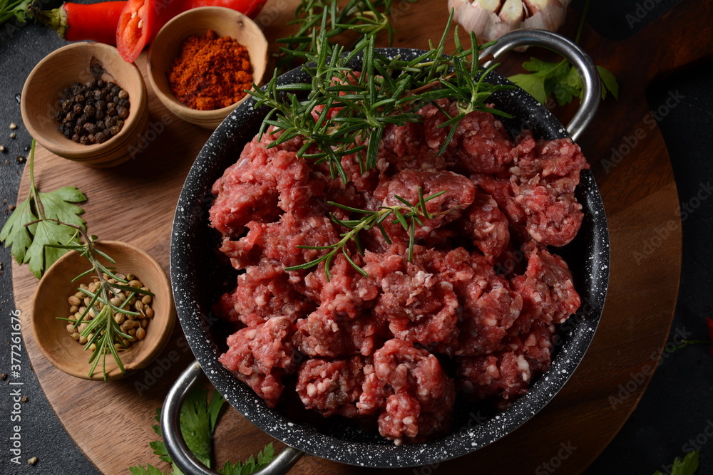 Minced beef. Ground meat with ingredients for cooking on black background Minced beef. Ground meat with ingredients for cooking on black background