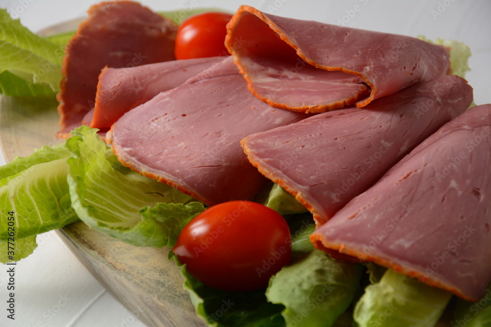 Peppered roast beef pastrami slices on lettuce leaf Peppered roast beef pastrami slices on lettuce leaf
