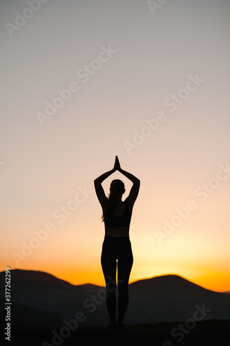 Canvas Print Silhouette woman balanced, practicing meditation, zen energy yoga in mountains