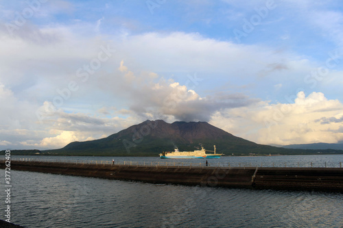 Ferry passing by Sakurajima during sunset.
