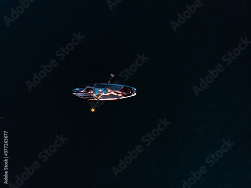 Attractive Woman on Stand Up Paddle Board, Woman paddling on sup board and enjoying turquoise transparent water. Tropical travel, wanderlust and water activity concept. Sunset and relax