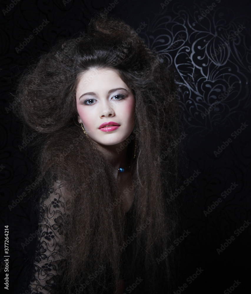 Beautiful young woman with long curly hair and evening make-up wearing black dress and jewerly Beautiful young woman with long curly hair and evening make-up wearing black dress and jewerly