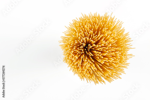 Concept of italian food. Top view of uncooked spaghetti isolated on white background