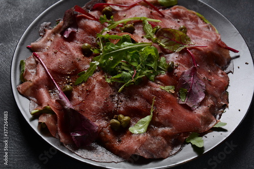 Beef Carpaccio  with parmesan, capers and arugula. With olive oil and soy sauce