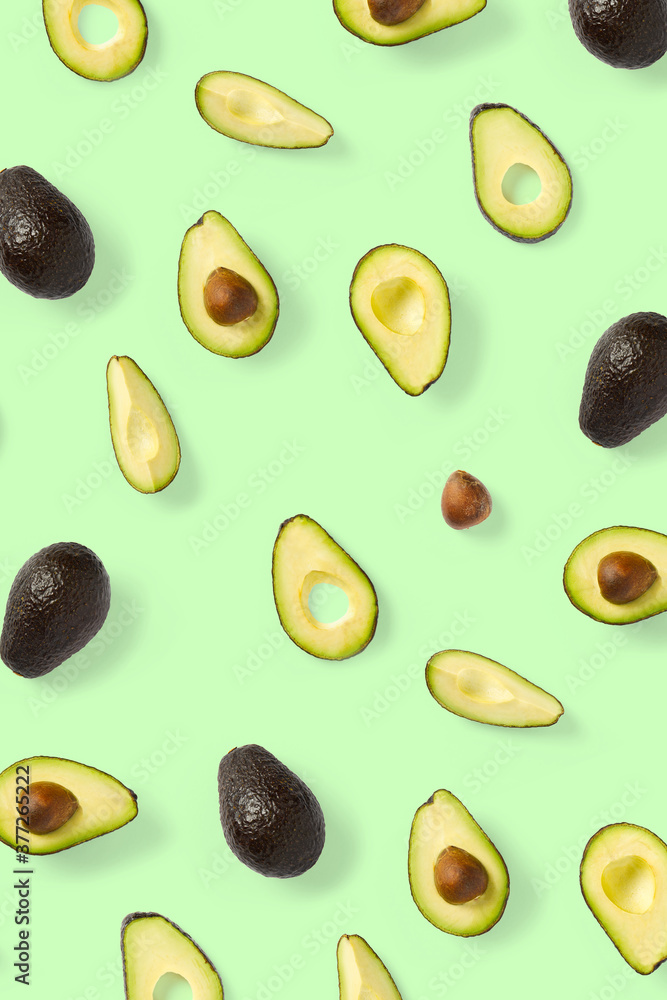 Avocado. Background made from isolated Avocado pieces on green background. Flat lay of fresh ripe avocados and avacado pieces. Avocado. Background made from isolated Avocado pieces on green background. Flat lay of fresh ripe avocados and avacado pieces.