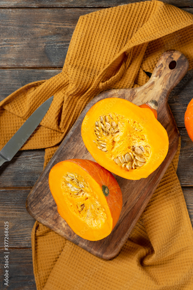 Hokkaido Pumpkins. Hokkaido pumpkins in a basket on a brown wooden table. The concept of the fall harvest. Top view with space for text