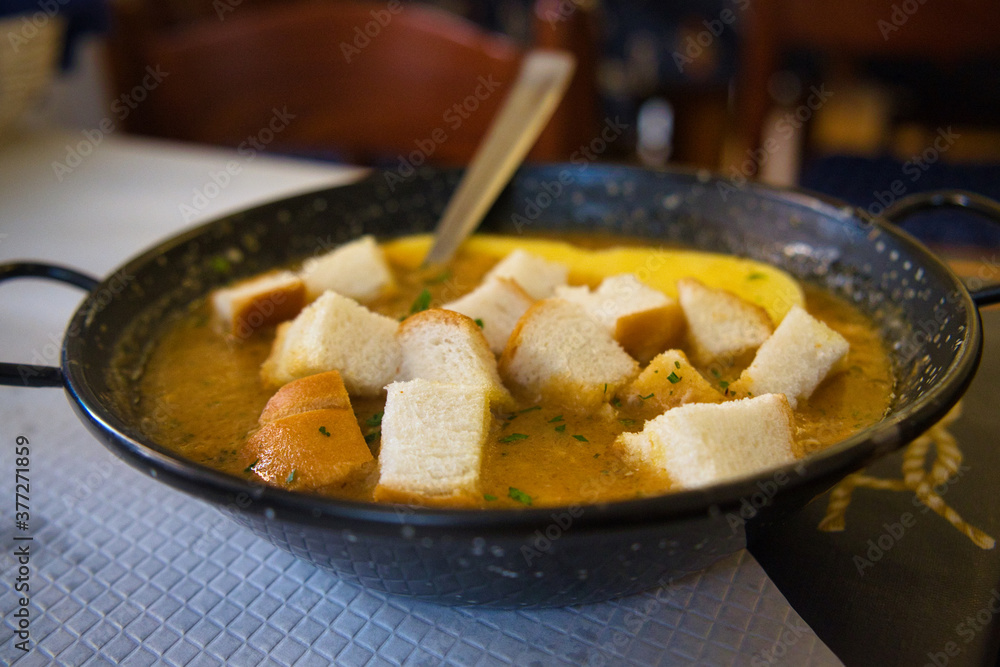 Delicious Italian fish soup with sardines, prawns, shells and bread croutons Delicious Italian fish soup with sardines, prawns, shells and bread croutons